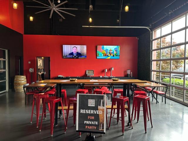 Bright taproom with big garage-door windows and bar seating